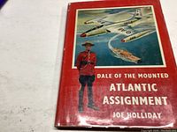 Front cover of the book showing the title, author, and illustrated images of a mounted police officer, aircraft, and ship.