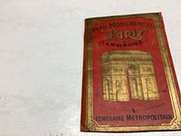 Front cover of the red booklet showing gold embossed Arc de Triomphe and title.