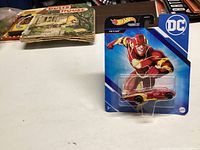 Image of unopened Hot Wheels The Flash die-cast car in blue packaging with DC Comics branding.