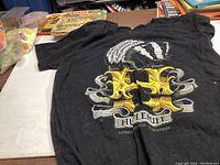 Photo of a black Hufflepuff T-shirt with badger and house emblem graphic on a flat surface.