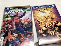Two Justice League comics with colorful covers featuring superheroes and villains in action poses, from DC Comics Rebirth series.