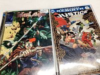Two comics shown: Warlands and Justice League Action #14. Covers feature warrior characters and superheroes in dynamic action poses with vibrant colors.