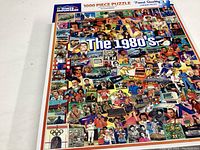 Box of a complete 1000 piece jigsaw puzzle titled 'The 1980s' by White Mountain Puzzles, showing a colorful collage of 1980s cultural icons and events.