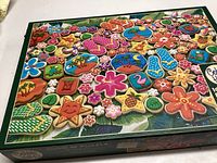 Box image showing the colorful tropical cookie designs featured in the puzzle