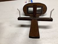 Top view of the vintage wooden stereo viewer showing dual rectangular lenses and metal supports on a flat wooden handle.