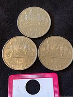 Three 1986 Canadian nickel dollars showing the Voyageur canoe design with the date 1986 and country name.