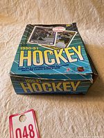 Photo of two unopened boxes of 1990-91 O-Pee-Chee Canadian NHL Hockey cards, box top with bold 'HOCKEY' text and player images.