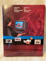 Front cover of the hardcover souvenir featuring a person using a computer and images of Canadian stamps and items.