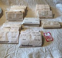 Packages of different Swarovski crystal types in original paper packets laid out on a cloth surface with visible product labels.