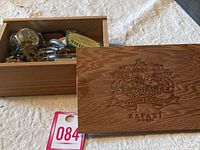 Wooden valet box open showing various small loose items inside including keys, coins, matchbox
