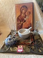 Photo showing all included items arranged together: religious picture, glass decanter and tumbler, porcelain mortar and pestle, blue and white trinket container, embroidered pillow sham, iron pad, and decorative fabric pieces.