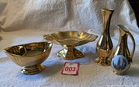 Four Royal Winton Grimwades gold lustre ceramic pieces on fabric background including jug, vase, compote dish, and gravy boat.