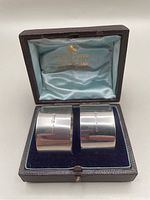 Two sterling silver napkin rings in fitted box with blue velvet base and light blue satin top stamped with Mappin & Webb gold logo.