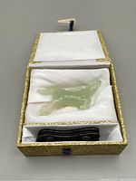 Horse statue nestled in lined fitted box with stand below