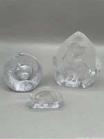 Three Mats Jonasson lead crystal sculptures: puppy, cat, and hedgehog on white background