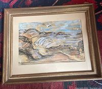 Framed pastel depicting rocky Maine coastline with seagulls in flight and ocean waves under cloudy sky. Frame shows signs of wear and chipping.