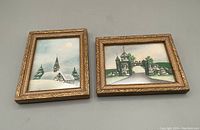 Two gold ornate framed vintage postage stamp artworks, one landscape and one portrait orientation, on neutral background