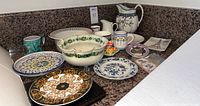 Overview photo showing entire collection of vintage European porcelain serving dishes and plates on granite counter