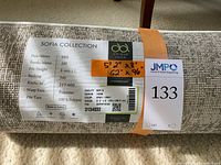 Label indicating Unique Loom Sofia Collection with product specs: 5'2" x 8', gray color design, jute backing, polyester warp yarn, 8mm pile height.