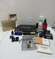 Multiple Chanel pencil boxes, lipsticks, skincare bottles and Lancôme boxes arranged on white table