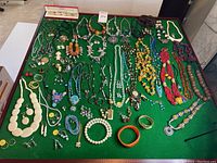 Wide view of entire jewelry lot on green felt surface
