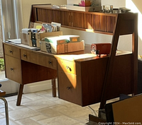 Full view of desk showing hutch, drawers, angled legs and surface wear