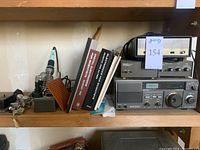 Shelf view showing soldering iron, manuals, frequency counter, converters and receiver