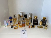 Overview of all 18 assorted perfume bottles arranged on white surface