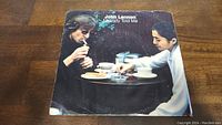 John Lennon Nobody Told Me 45rpm sleeve showing Lennon and a companion at a table with cups and ashtray, photo taken to show the front cover condition and design