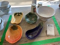 Photo showing 4 William Sonoma fruit-shaped ceramic dip bowls, 2 ceramic shakers, and 1 ceramic bowl on stem arranged on a surface with green tape marks.