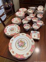Overall view of 65-piece China set arranged on wooden table