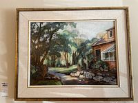 Framed acrylic painting on masonite panel depicting a garden scene with pathway, trees, and house, showing full view with frame and mat.