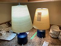 Two lamps side by side on countertop showing height difference