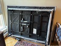 Underside view of adjustable bed frame showing black metal structure, motors and wiring