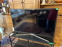 Front view of Samsung TV on stand in room setting