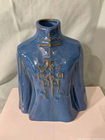 Front view of the blue Chinese workman's jacket vase showing detailed gold decorative elements and glossy blue glaze.