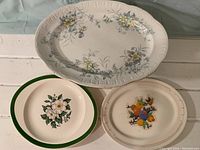 Photo of all 3 platters including large floral ironstone platter, southwestern themed platter, and gardenia flower platter.