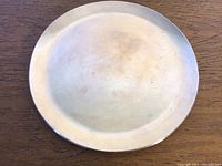Top view of the round sterling silver plate showing surface condition and shape.