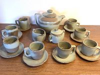 Full view of coffee set including pot, sugar bowl, creamer, cups and saucers