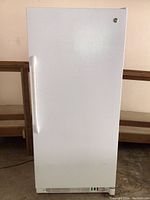 Front exterior view of white upright freezer with locking handle