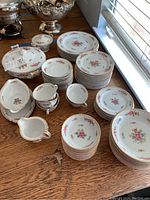 Vintage Adline China Florinda pattern dinnerware set arranged on table showing various plates, cups, saucers, and serving pieces with floral and gold trim.