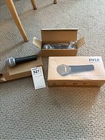 Two Pyle professional dynamic handheld microphones, one in box and one out of box, with packaging and tag