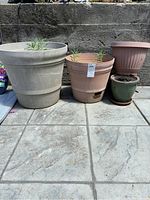 Three pots: large beige planter with succulent, large terracotta pot, small green ceramic pot