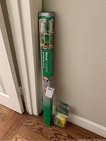 Full view of the Gila Heat Control Window Film box and the application kit in original packaging on the floor against a wall.