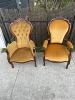 Two antique parlour chairs side by side outdoors showing overall condition and upholstery detail.