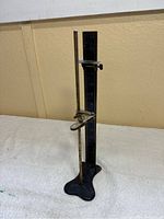 Full view of the antique skirt gauge measuring device on a flat surface.