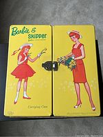 Front and back of the yellow Barbie & Skipper Carrying Case with illustrated artwork of Barbie and Skipper and metal clasp closure