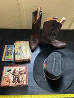 Lot items arranged showing cowboy boots, cowboy hat, Lone Ranger lunch box, and books.