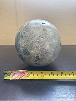 Metal globe shown next to tape measure indicating approximately 6 inches in diameter with visible moon-like crater surface.