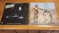 Both Star Wars LP record covers laid side by side on a wooden surface.